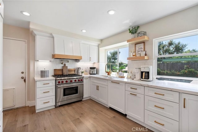 11691 Mount Baker Ct, Rancho Cucamonga, CA 91737 - kitchen with premium range, a sink, tasteful backsplash, white cabinets, and light wood-style floors