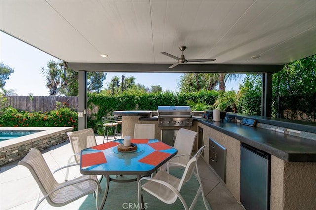 view of patio / terrace with fence, exterior kitchen, outdoor dining area, grilling area, and ceiling fan