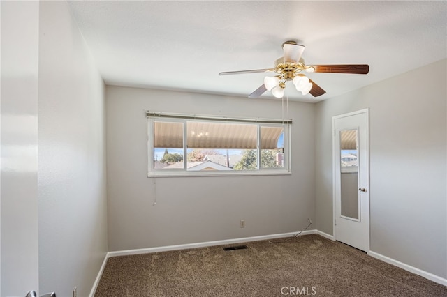 carpeted empty room featuring baseboards, ceiling fan, and visible vents
