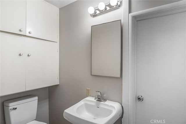 half bath featuring toilet and a sink