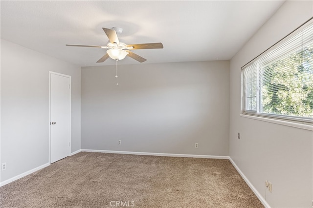 empty room featuring carpet floors, ceiling fan, and baseboards