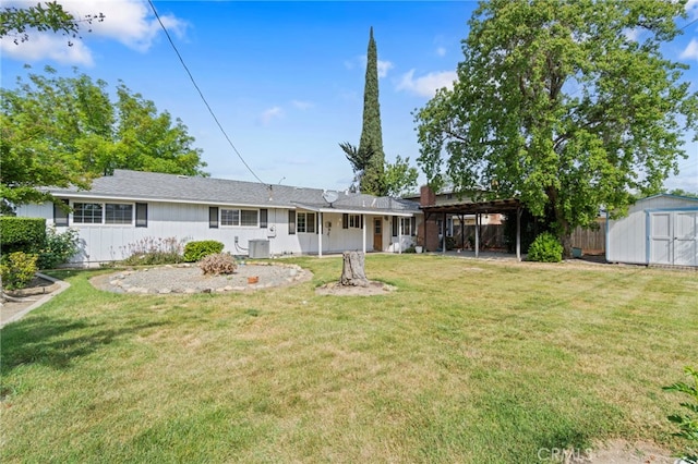 117 Spring Way, Madera, CA 93637 - back of property with a storage shed, an outdoor structure, a lawn, and central AC