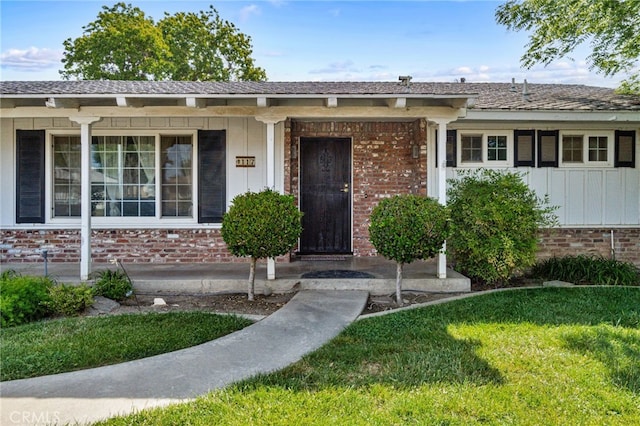 117 Spring Way, Madera, CA 93637 - view of front of house with a porch, a front lawn, board and batten siding, and brick siding