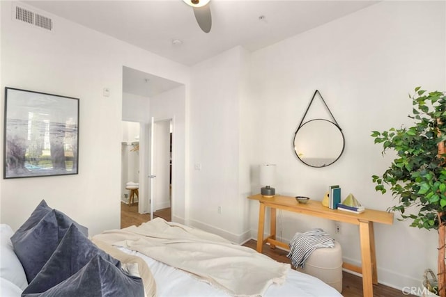 bedroom with baseboards, wood finished floors, and visible vents