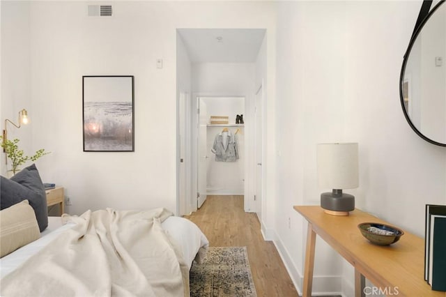 bedroom with visible vents, baseboards, and light wood-type flooring