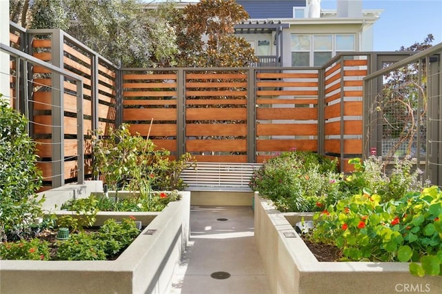 exterior space with fence and a vegetable garden