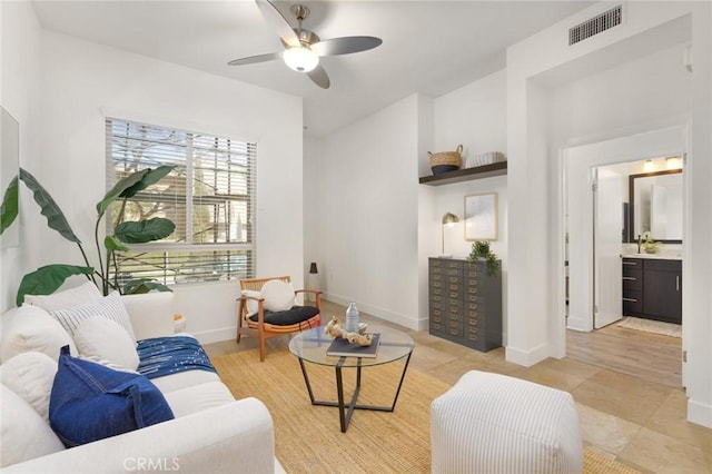 living room featuring baseboards, ceiling fan, and visible vents