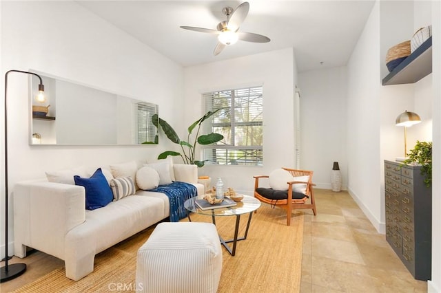 sitting room with a ceiling fan and baseboards