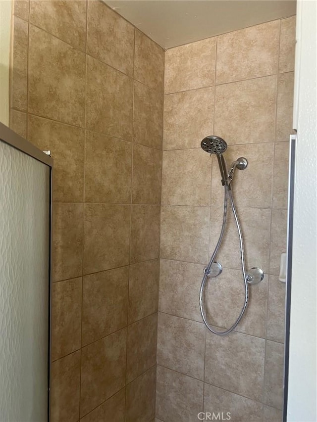 interior details featuring tiled shower