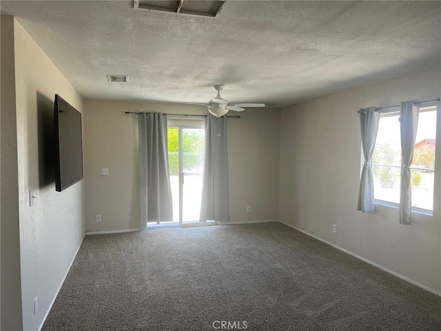 unfurnished room with carpet floors, a ceiling fan, a textured ceiling, and visible vents