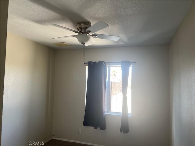 spare room with visible vents, a ceiling fan, a textured ceiling, and baseboards