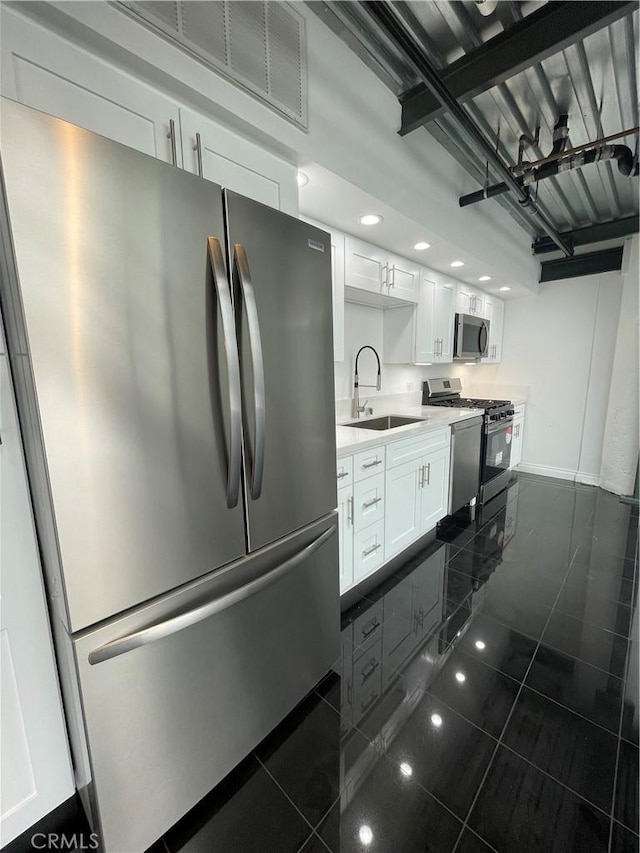 420 S San Pedro St Unit 102, Los Angeles, CA 90013 - kitchen with appliances with stainless steel finishes, a sink, white cabinets, dark tile patterned floors, and baseboards