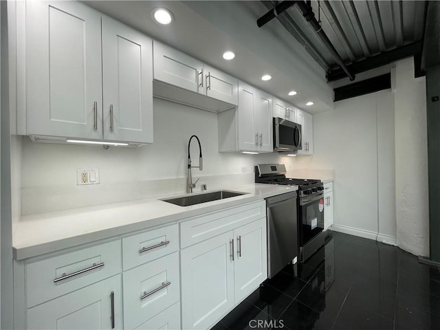 420 S San Pedro St Unit 102, Los Angeles, CA 90013 - kitchen featuring a sink, stainless steel appliances, recessed lighting, white cabinets, and baseboards