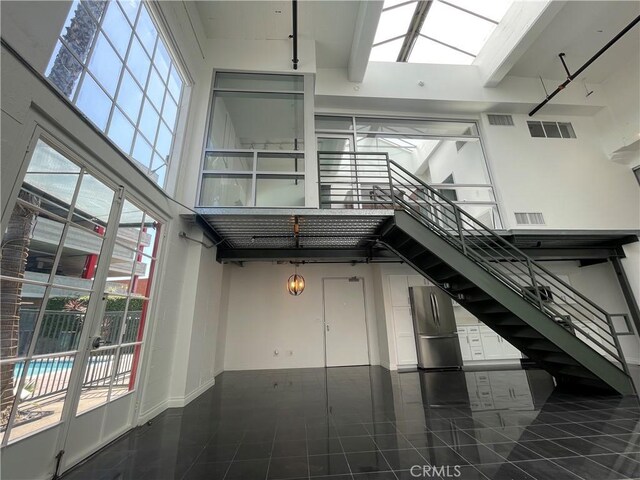 420 S San Pedro St Unit 102, Los Angeles, CA 90013 - staircase with tile patterned flooring, a skylight, and baseboards