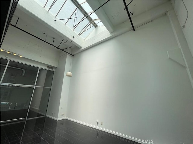 420 S San Pedro St Unit 102, Los Angeles, CA 90013 - empty room with a skylight, dark tile patterned floors, and baseboards