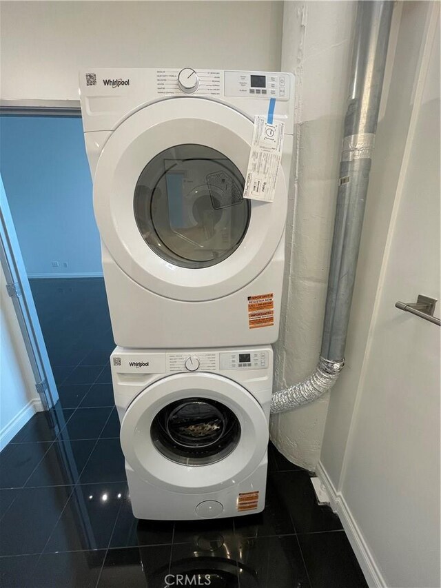 420 S San Pedro St Unit 102, Los Angeles, CA 90013 - washroom featuring stacked washer / drying machine, dark tile patterned flooring, and baseboards