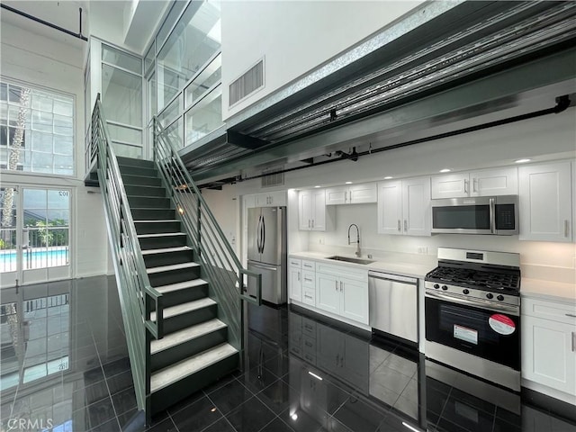420 S San Pedro St Unit 102, Los Angeles, CA 90013 - kitchen with appliances with stainless steel finishes, a sink, white cabinetry, and light countertops