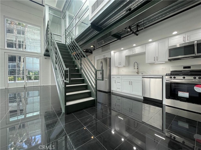 420 S San Pedro St Unit 102, Los Angeles, CA 90013 - kitchen featuring stainless steel appliances, a sink, white cabinetry, and light countertops