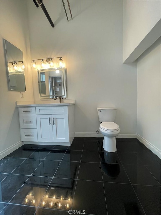 420 S San Pedro St Unit 102, Los Angeles, CA 90013 - bathroom featuring high vaulted ceiling, tile patterned flooring, baseboards, toilet, and vanity