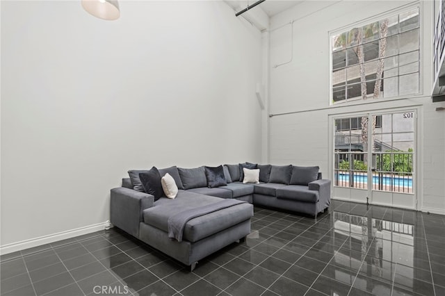 420 S San Pedro St Unit 102, Los Angeles, CA 90013 - living area featuring dark tile patterned flooring, healthy amount of natural light, and a towering ceiling