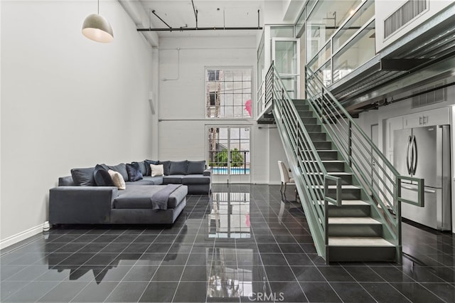 420 S San Pedro St Unit 102, Los Angeles, CA 90013 - living room with a towering ceiling, stairs, and dark tile patterned floors