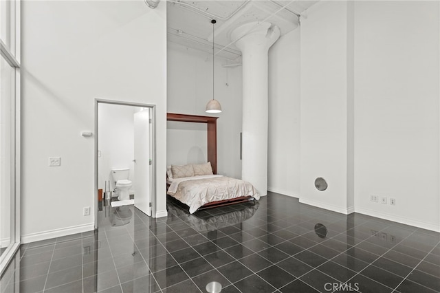 420 S San Pedro St Unit 102, Los Angeles, CA 90013 - bedroom featuring dark tile patterned flooring, a towering ceiling, and connected bathroom