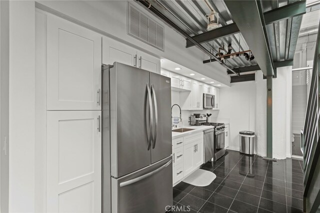 420 S San Pedro St Unit 102, Los Angeles, CA 90013 - kitchen featuring stainless steel appliances, dark tile patterned floors, white cabinets, light countertops, and recessed lighting