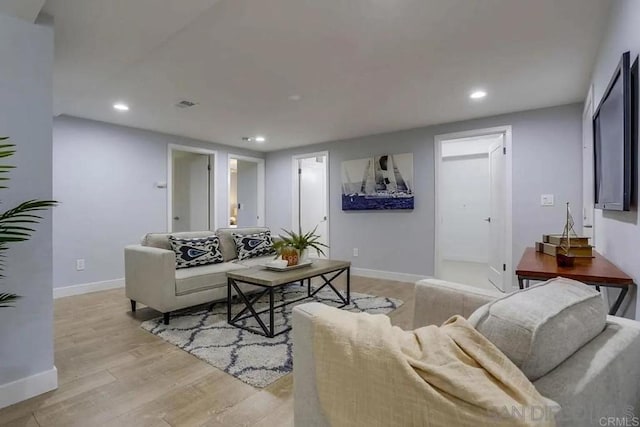 living area featuring recessed lighting, baseboards, and light wood-type flooring