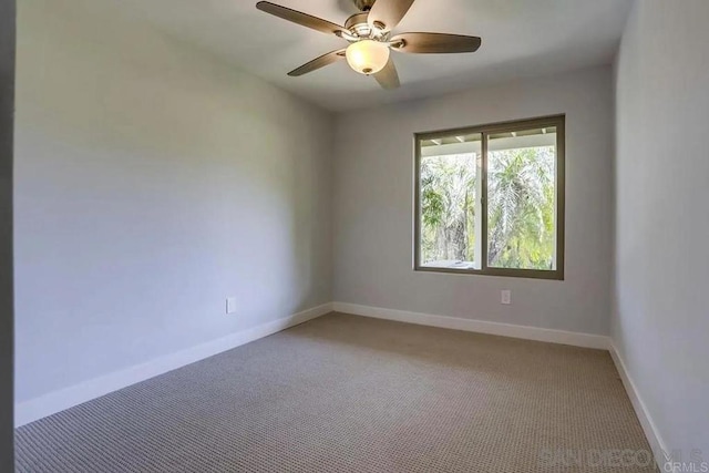 unfurnished room featuring a ceiling fan, baseboards, and light carpet