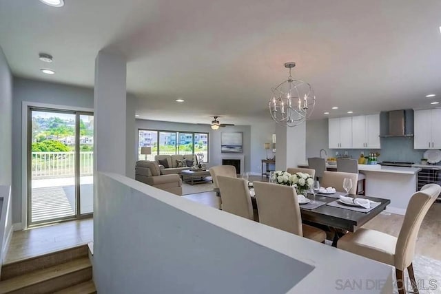 dining area featuring recessed lighting, ceiling fan with notable chandelier, and dark wood-style flooring