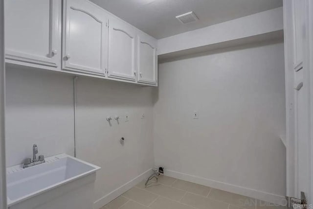 laundry area with visible vents, baseboards, a sink, cabinet space, and light tile patterned floors
