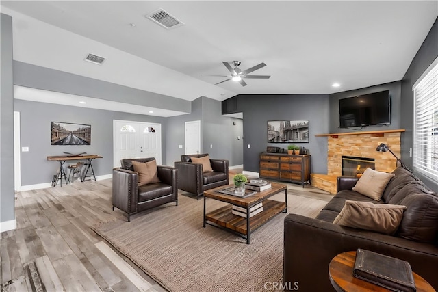58957 Pueblo Trl, Yucca Valley, CA 92284 - living room with visible vents, a stone fireplace, and light wood-type flooring