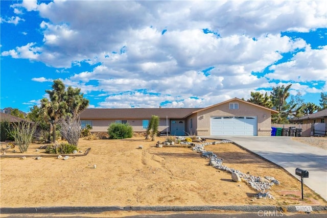 58957 Pueblo Trl, Yucca Valley, CA 92284 - ranch-style home featuring concrete driveway, stucco siding, and an attached garage