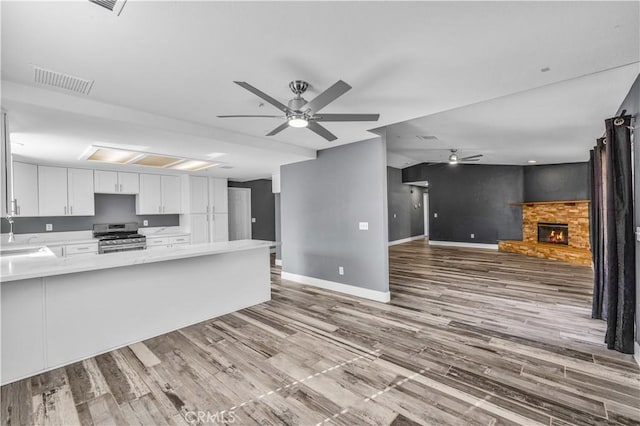 58957 Pueblo Trl, Yucca Valley, CA 92284 - kitchen featuring a ceiling fan, visible vents, light countertops, white cabinets, and stainless steel range with gas cooktop