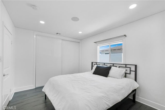 bedroom with visible vents, a closet, baseboards, recessed lighting, and dark wood finished floors