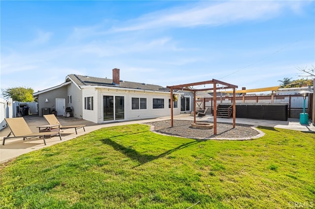 back of house with a chimney, a fenced backyard, an outdoor fire pit, a yard, and a patio