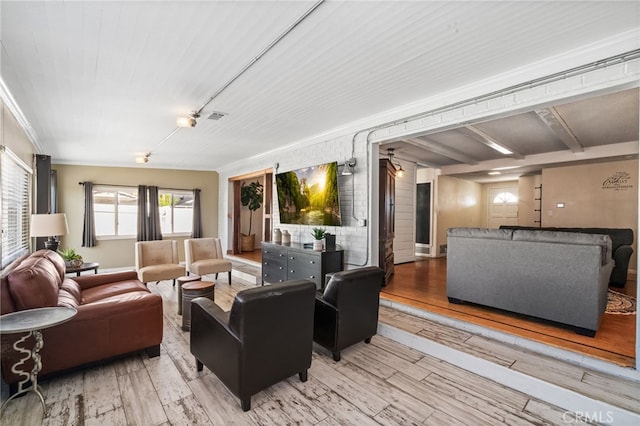 living area featuring visible vents, baseboards, and wood finished floors