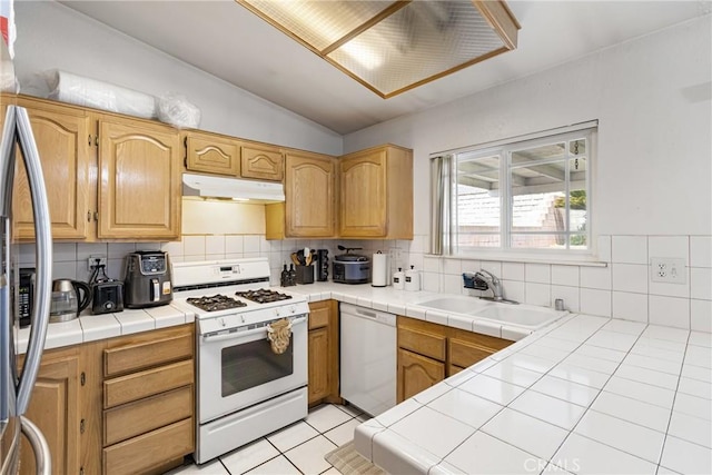 9684 Hemlock St, Rancho Cucamonga, CA 91730 - kitchen featuring white appliances, under cabinet range hood, tile countertops, tasteful backsplash, and vaulted ceiling