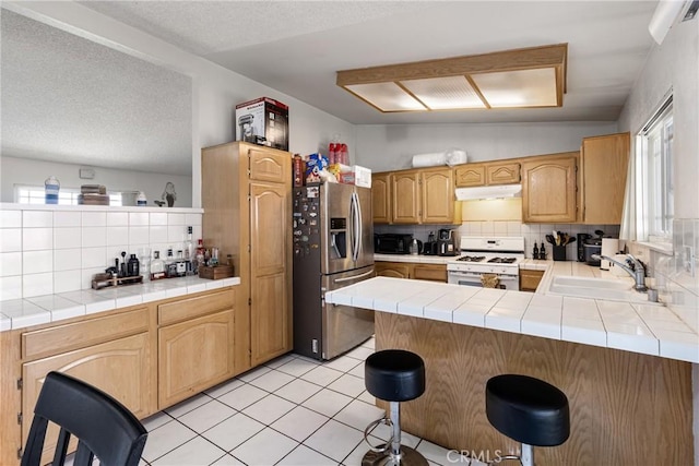 9684 Hemlock St, Rancho Cucamonga, CA 91730 - kitchen featuring white range with gas stovetop, stainless steel fridge with ice dispenser, under cabinet range hood, a peninsula, and tasteful backsplash
