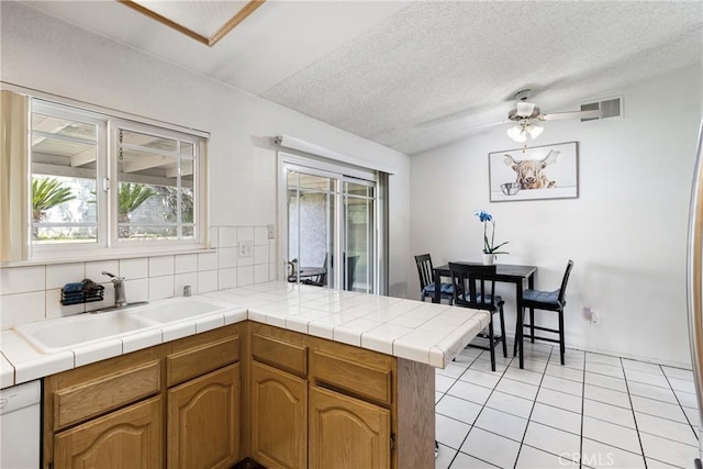 9684 Hemlock St, Rancho Cucamonga, CA 91730 - kitchen featuring a peninsula, light tile patterned floors, tasteful backsplash, ceiling fan, and a textured ceiling