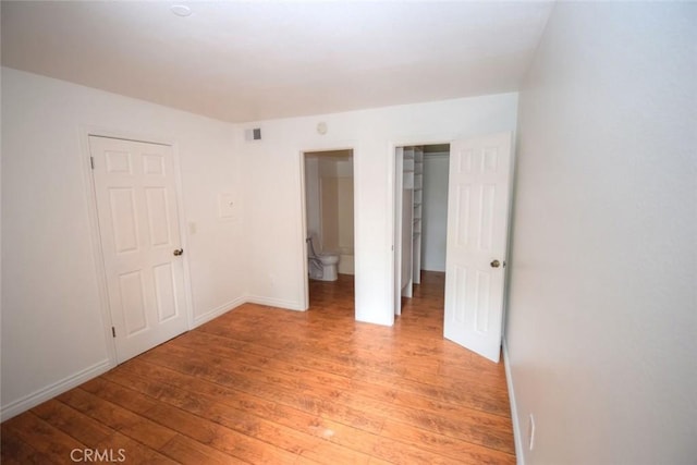 unfurnished bedroom featuring light wood-type flooring, baseboards, and visible vents