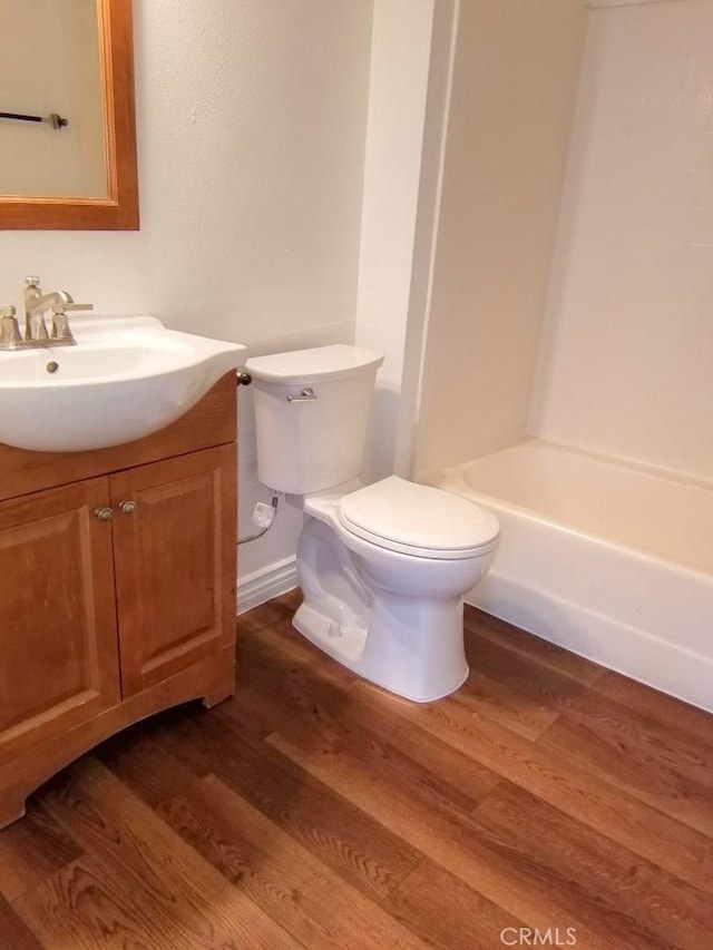 full bath featuring vanity, baseboards, toilet, and wood finished floors