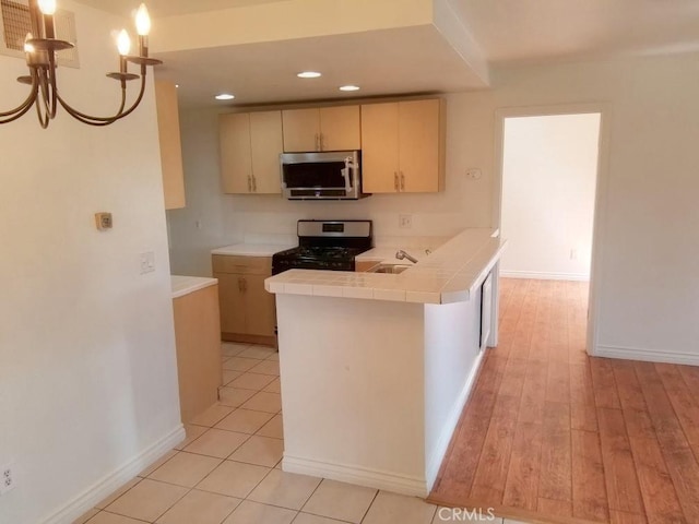 1052 Calle Del Cerro Unit 705, San Clemente, CA 92672 - kitchen with appliances with stainless steel finishes, tile counters, recessed lighting, baseboards, and a peninsula