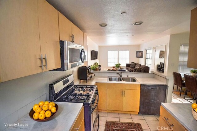 1052 Calle Del Cerro Unit 705, San Clemente, CA 92672 - kitchen with stainless steel appliances, open floor plan, light countertops, a textured ceiling, and light tile patterned flooring
