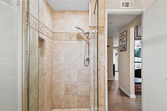 1528 E San Alto Ave, Orange, CA 92865 - bathroom with visible vents, baseboards, a stall shower, and wood finished floors