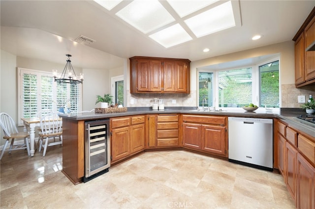 kitchen with visible vents, dark countertops, a sink, beverage cooler, and stainless steel appliances