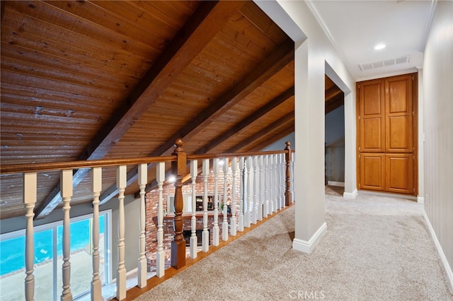 hall featuring visible vents, carpet flooring, baseboards, and lofted ceiling with beams