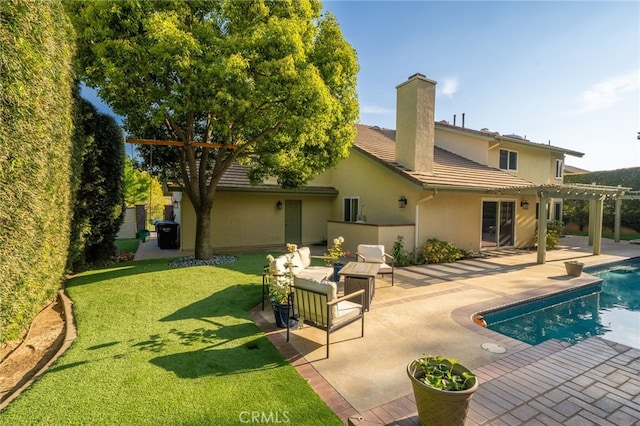rear view of property featuring a pergola, a tile roof, stucco siding, a chimney, and a yard