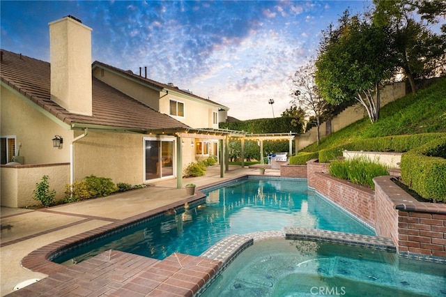 pool at dusk with a pergola, a pool with connected hot tub, and a patio