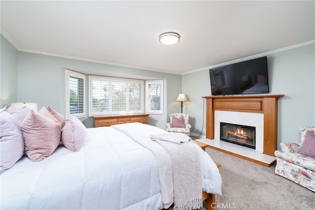 carpeted bedroom with ornamental molding and a glass covered fireplace